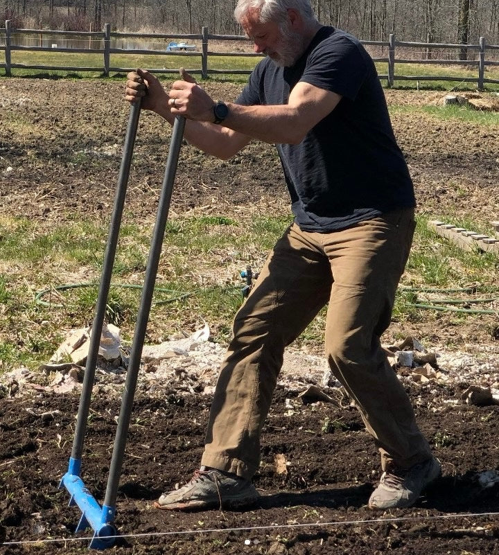 The all steel four tine All Day Treadlite Broadfork is a lightweight high strength tool cultivating the soil at the Elmbrook Farm in Canada